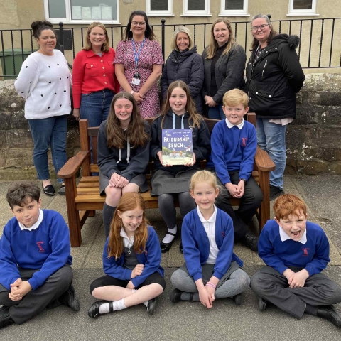 Friends of Follifoot School present Friendship Bench to Follifoot school children Back row L to R: Sophie Griffiths from Harvey George Limited; Laura Hartley, Chair of FOFS; Rebecca Holland, Headteacher at Follifoot Primary School; Claire Hartley, Vicky Hodgson and Sam Riley from FOFS Middle row L to R: Lizzie, Annabelle, William Front row L to R: Elliot, Jessica, Florence, Jasper