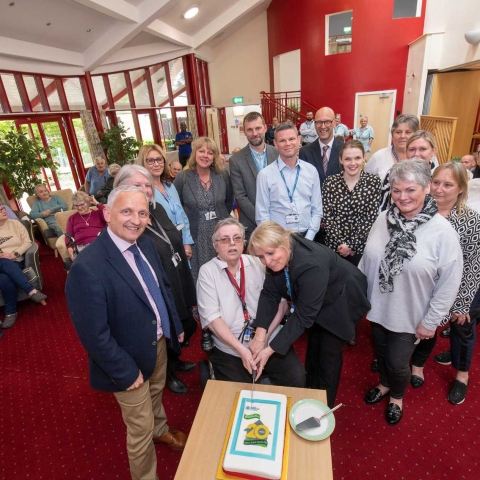 North Yorkshire Council’s executive member for health and adult services, Cllr Michael Harrison, left, and the corporate director for health and adult services, Richard Webb, back centre, with staff and residents at North Yorkshire’s first Extra Care site, The Orchards, in Brompton, near Northallerton, which celebrated its 20th anniversary this week. The anniversary cake is being cut by Ruth Fuller, who moved into The Orchards when it opened.