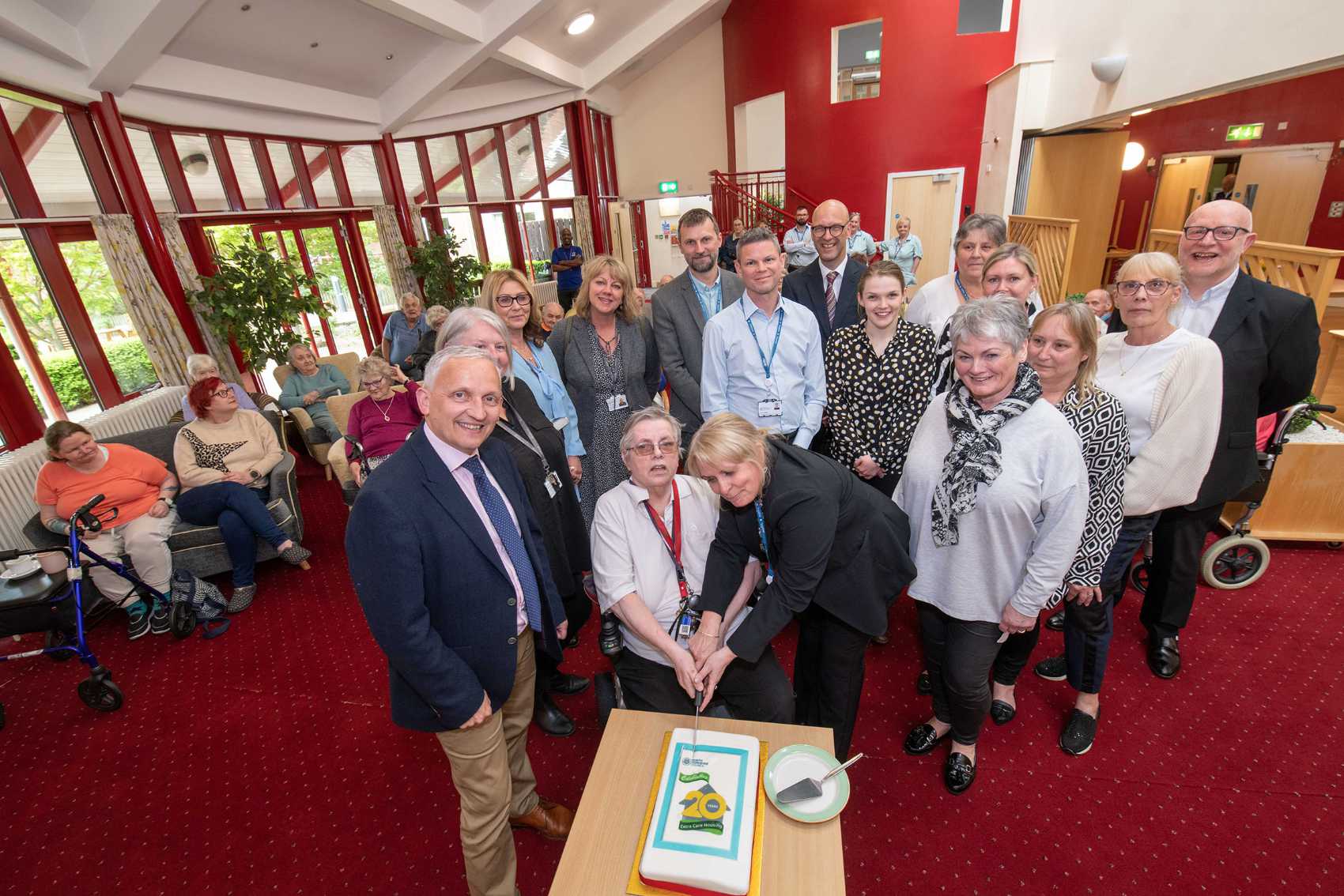 North Yorkshire Council’s executive member for health and adult services, Cllr Michael Harrison, left, and the corporate director for health and adult services, Richard Webb, back centre, with staff and residents at North Yorkshire’s first Extra Care site, The Orchards, in Brompton, near Northallerton, which celebrated its 20th anniversary this week. The anniversary cake is being cut by Ruth Fuller, who moved into The Orchards when it opened.