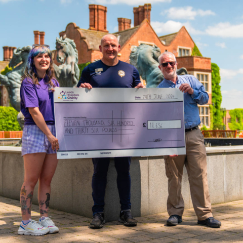Rob Rawlinson, Head of Sport and David Payne, Head of English at Queen Ethelburga’s Collegiate present the final cheque from the fundraiser to Charlotte Bray from Leeds Hospitals Charity