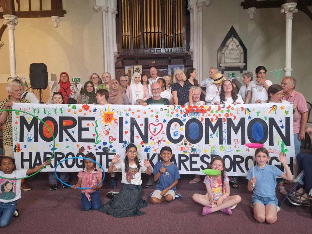 Inside the URC behind the brilliant banner created by children & adults attending the Great Get Together