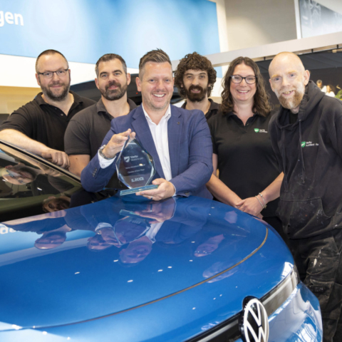 Phil Simpson, Manager of the Accident Repair Centre (holding trophy) with some of the team