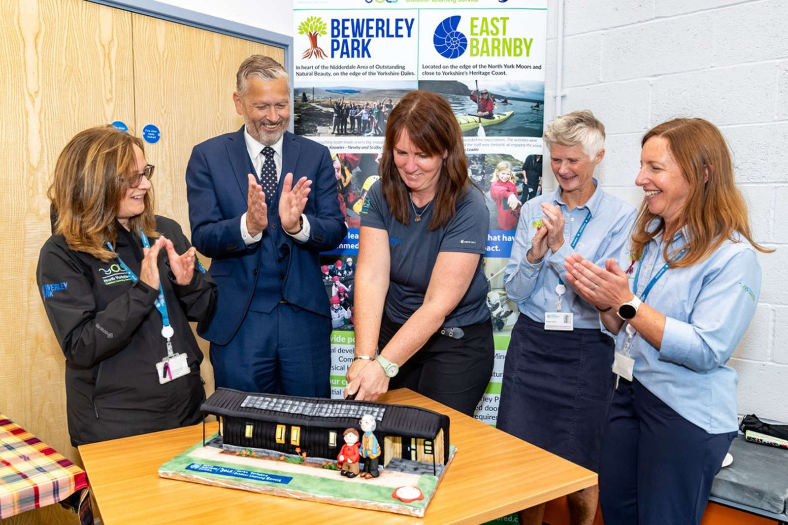 Outdoor learning teacher and expert baker Kate Crawford (centre) created a chocolate cake replicating the new build
