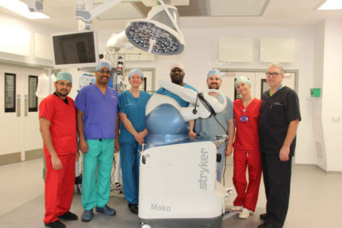 Andrew Port (pictured far right) and wider team with the Mako robotic arm