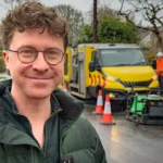 (credit - Leeds City Council): Leeds City Council’s deputy leader and executive member for economy, transport and sustainable development, Councillor Jonathan Pryor, with the Thermal Road Repairs machine filling potholes in a Leeds residential area.