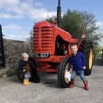 Mark Dean's sons 2-year-old George and James (4) put the finishing touches to his Massey Harris Tractor