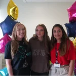 Sophie Chaplin celebrates her GCSE results by posing with tutors Laura Heward (left) and Naduni Silva (right) accompanied by star-shaped balloons